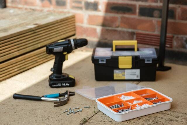 drill tool-box box of screws and nails and a hammer on sidewalk